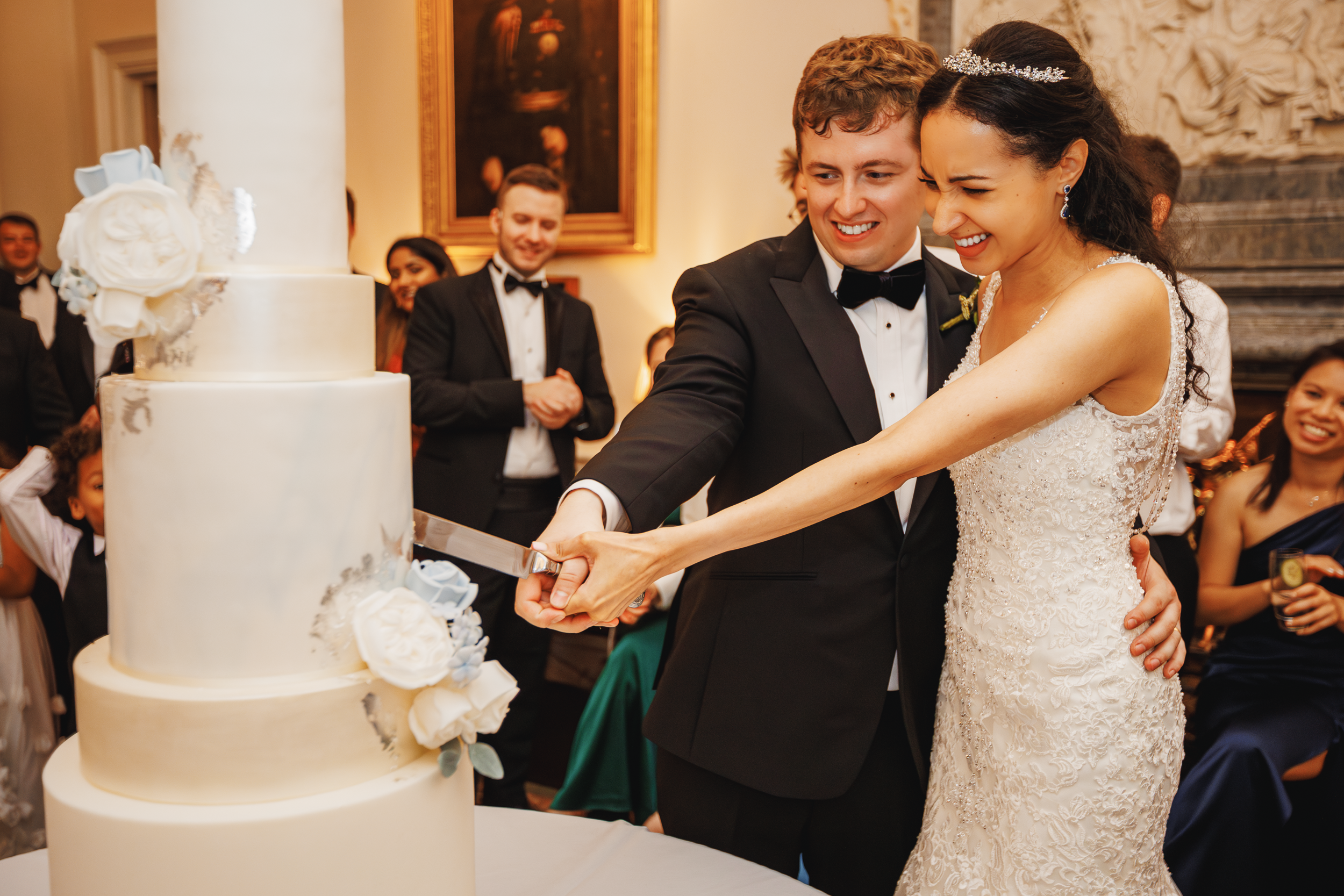 Bride and Groom Cutting the Wedding Cake at the In and Out Club 21 Bride and groom cutting their wedding cake while guests watch at the In and Out Club reception